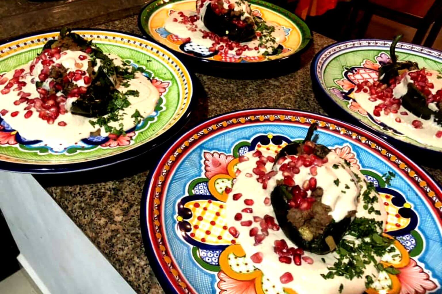 Four Chiles en Nogada on beautiful plates.