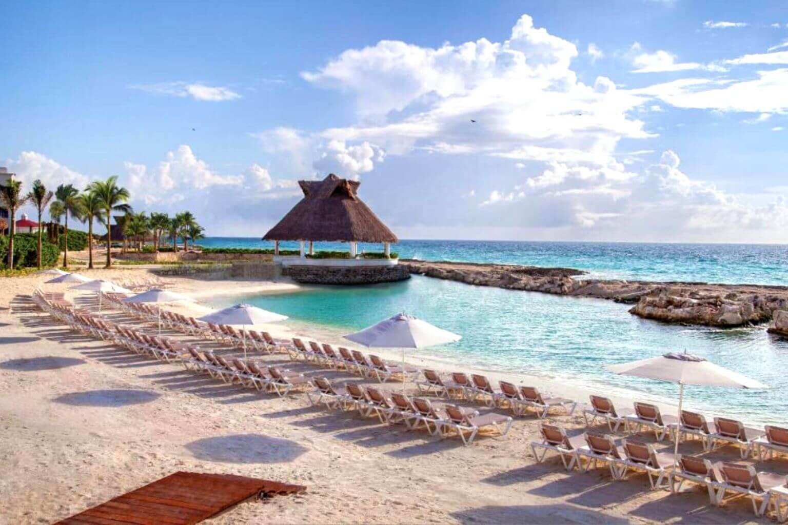 Loungers and an event palapa on the beach at the Hard Rock Riviera Maya Heaven Hotel.