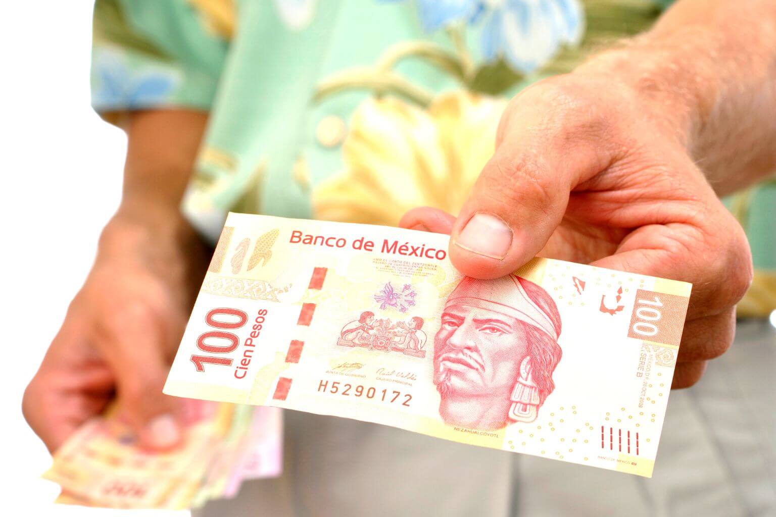 Man handing over a 100 pesos bill