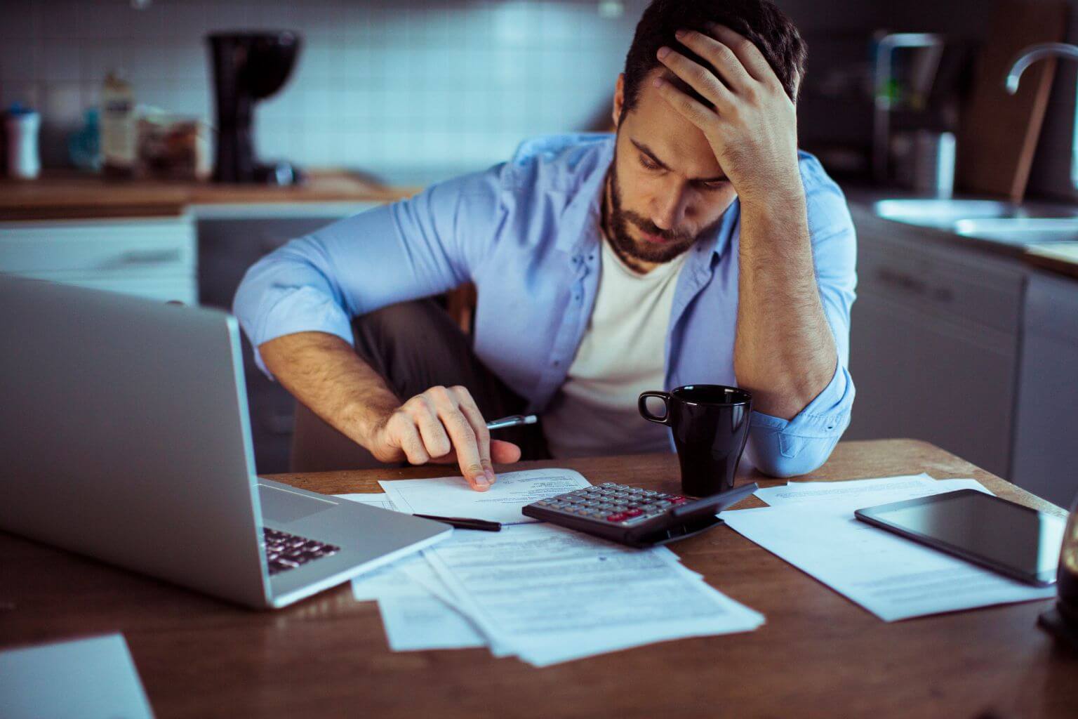 Man looking worried paying bills